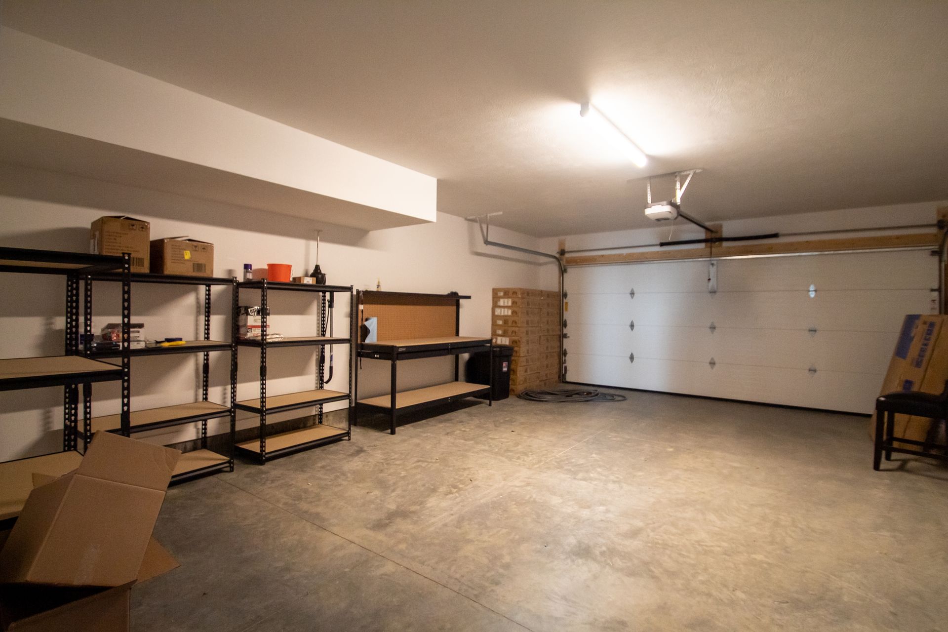 An empty garage with shelves and a garage door.