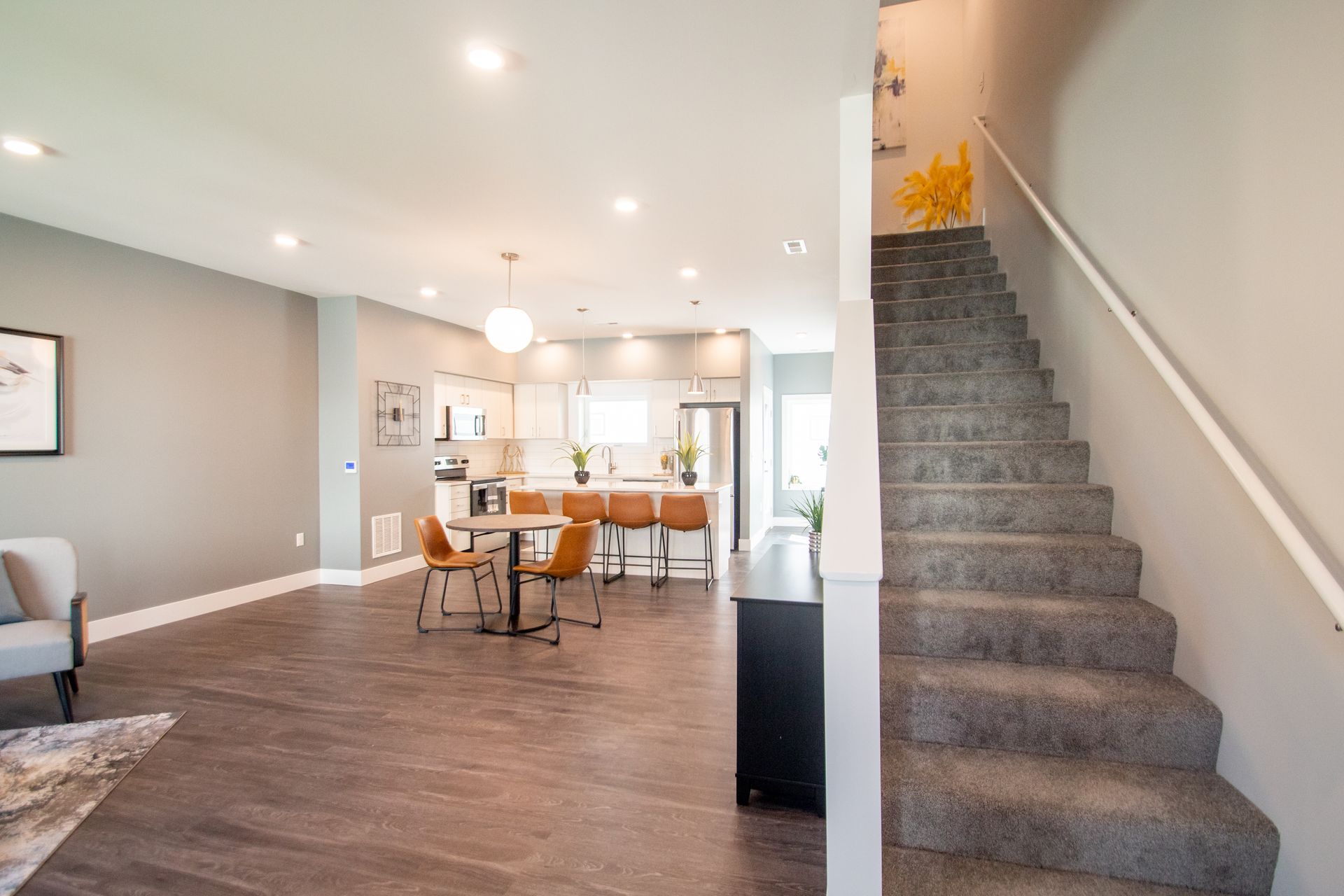 A living room with hardwood floors and stairs leading up to the second floor.