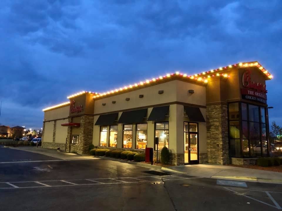 A chick fil a restaurant is lit up at night
