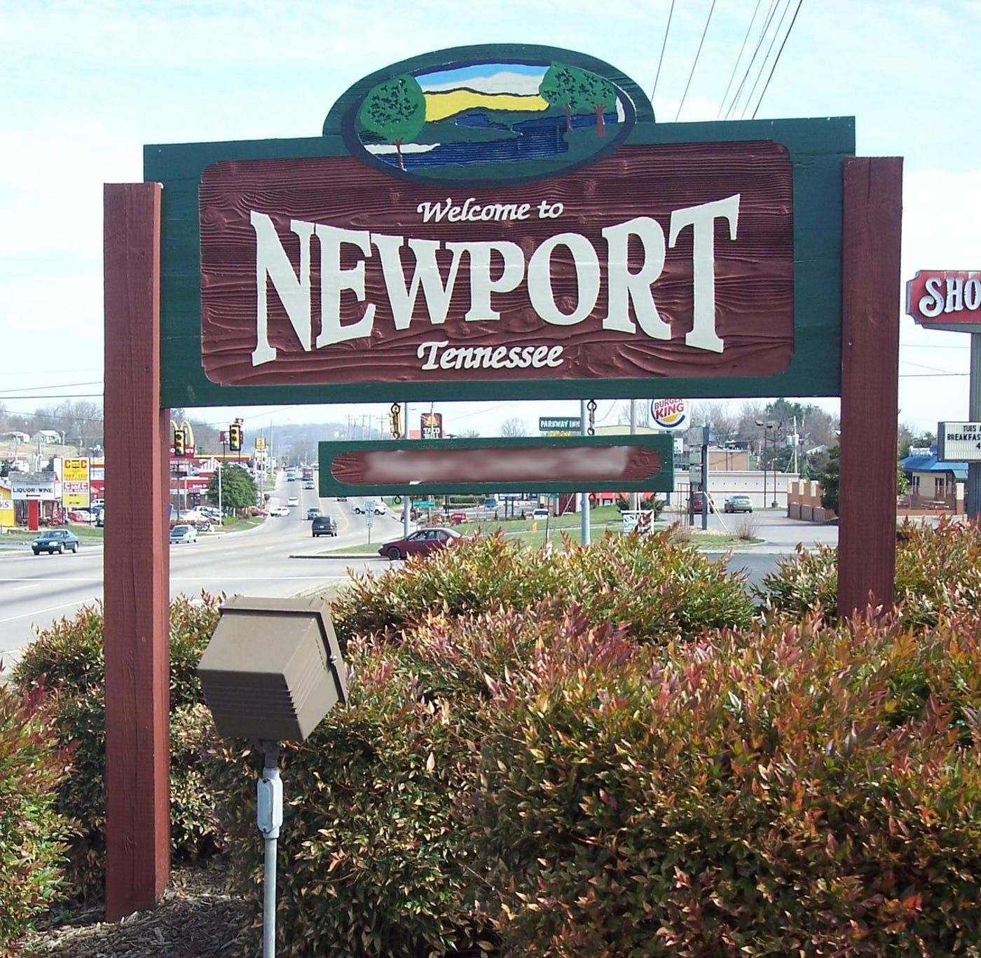 Welcome to Newport, Tennessee, sign by a road, with bushes and traffic in the background in Newport, TN. 
