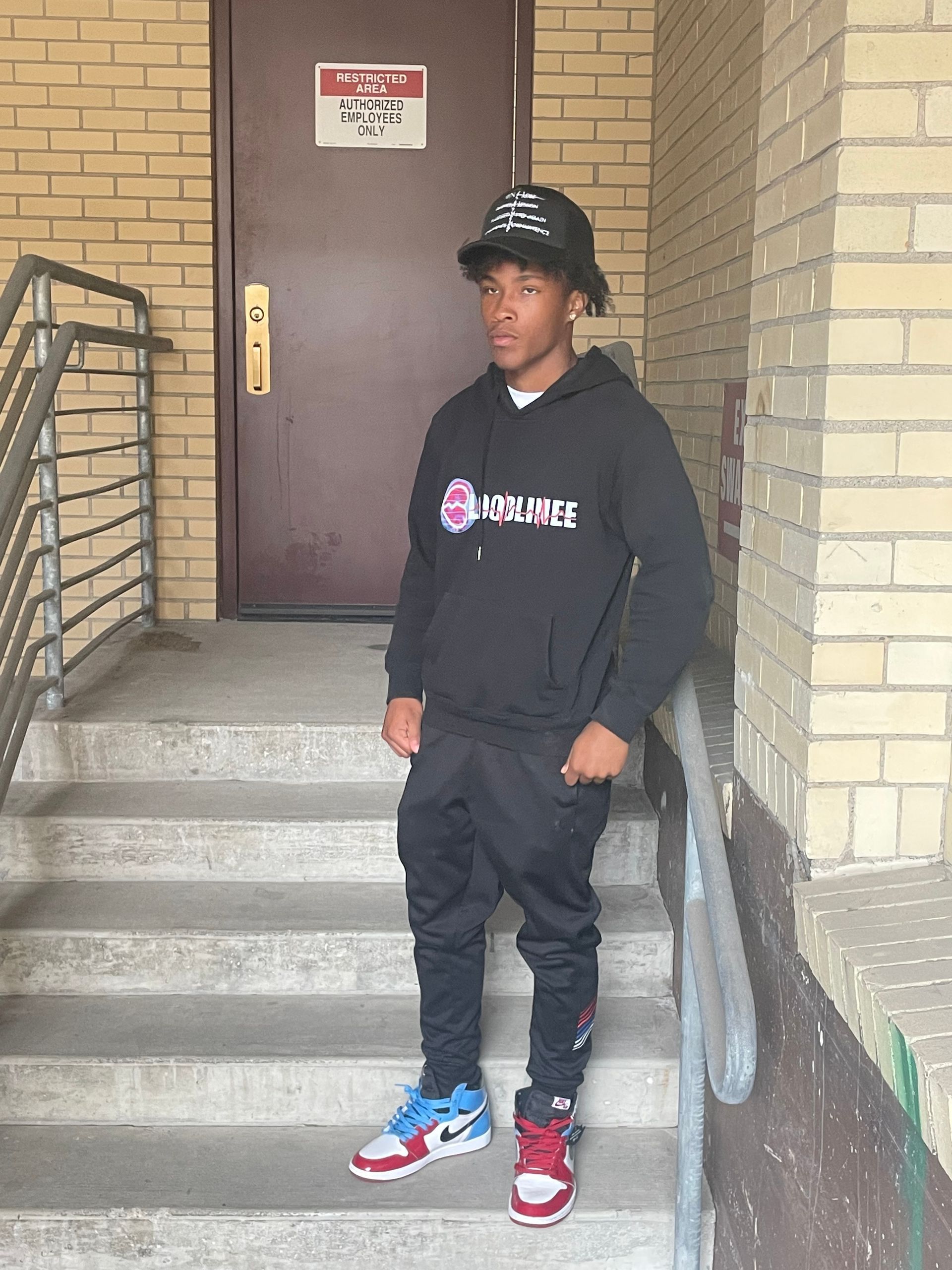 Black hoodie with a front graphic of a stylized design and the words 