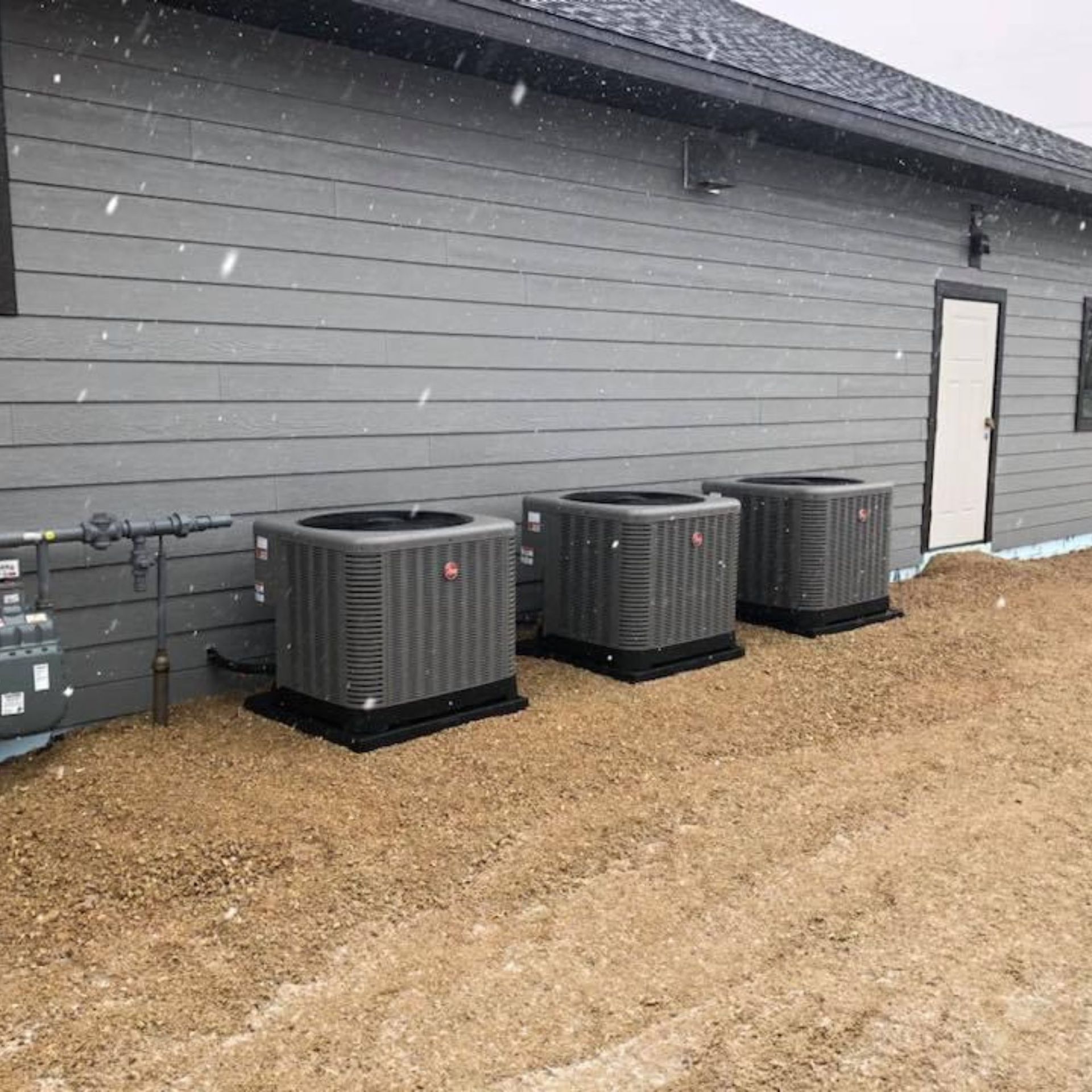 Lake Area Heating and Cooling LLC | Three air conditioners are sitting outside of a building.