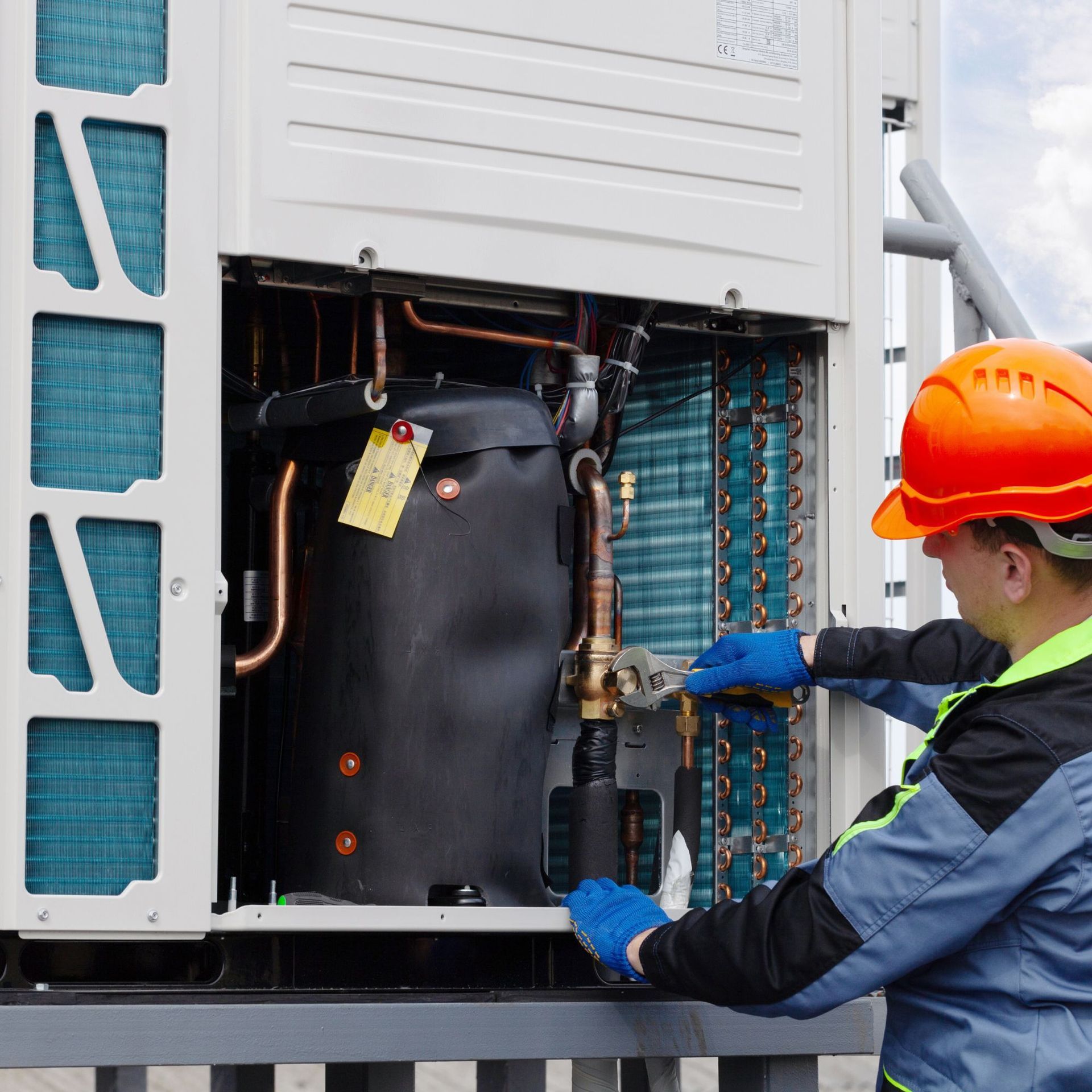 Lake Area Heating and Cooling LLC | A man wearing green gloves is working on a water heater