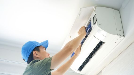 Lake Area Heating and Cooling LLC | A man in a blue hat is working on an air conditioner.