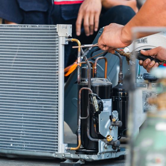 Lake Area Heating and Cooling LLC | A man is working on an air conditioner with a wrench.