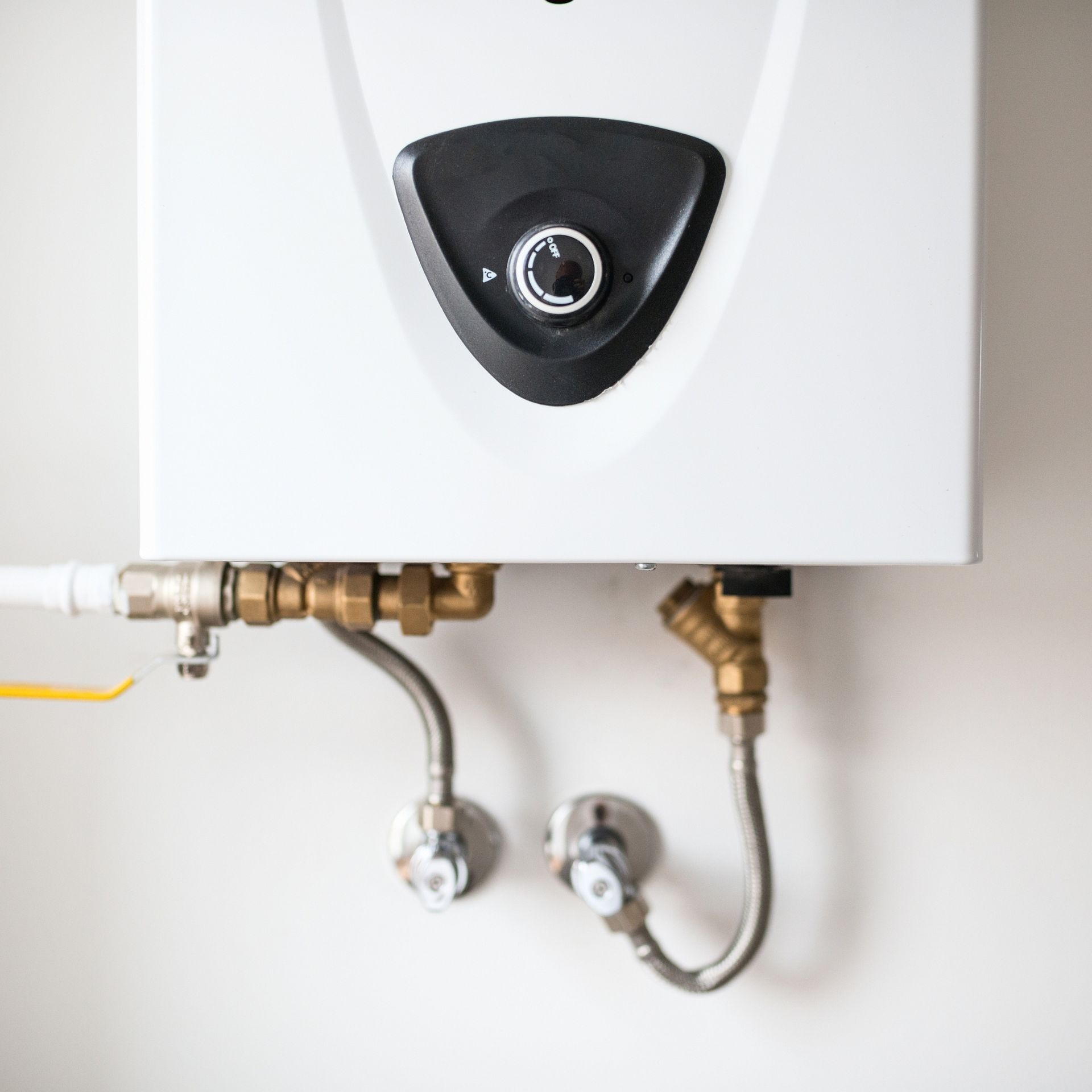 Lake Area Heating and Cooling LLC | A white water heater with brass pipes attached to it