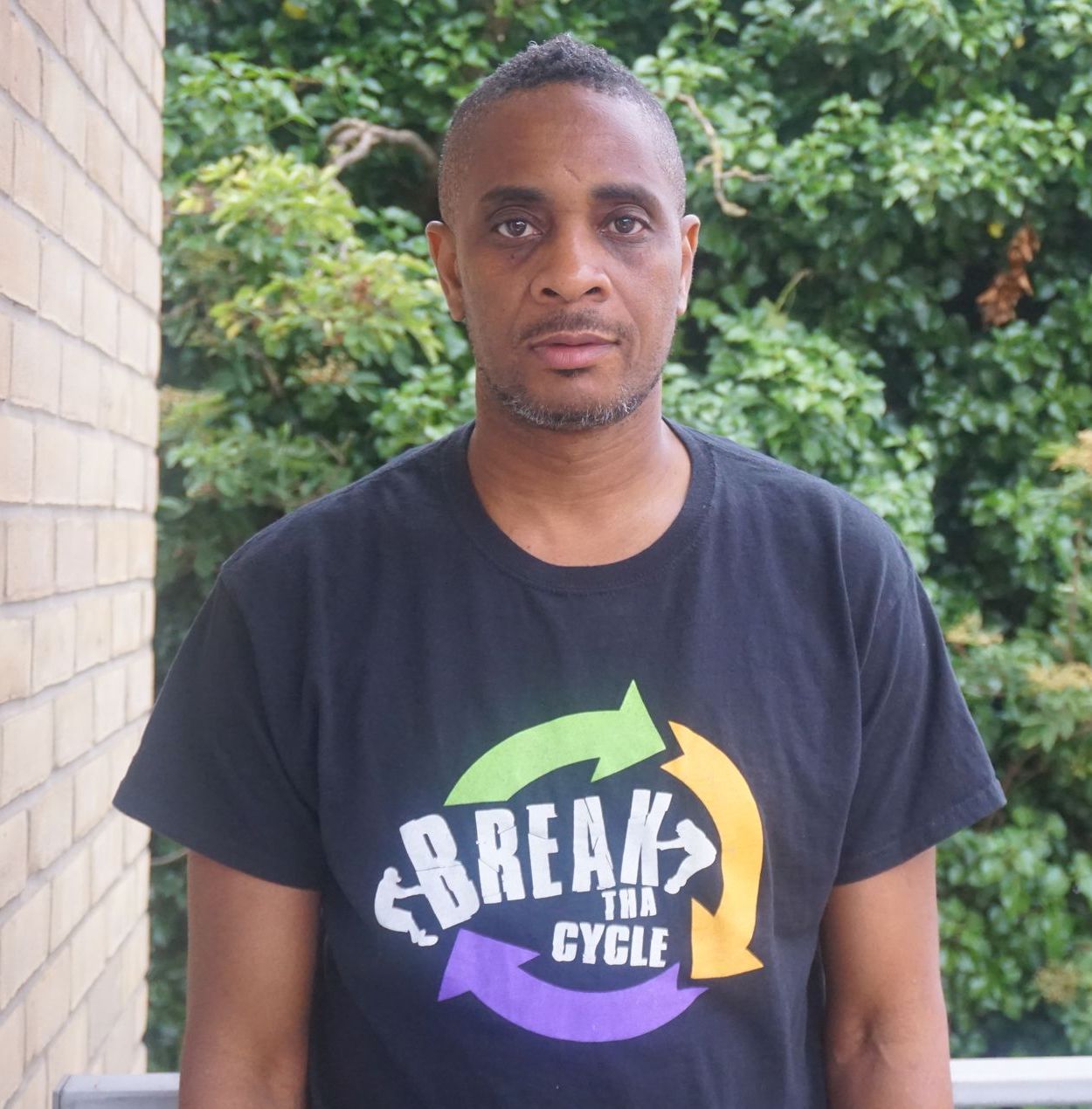 A man wearing a black t-shirt that says break the cycle