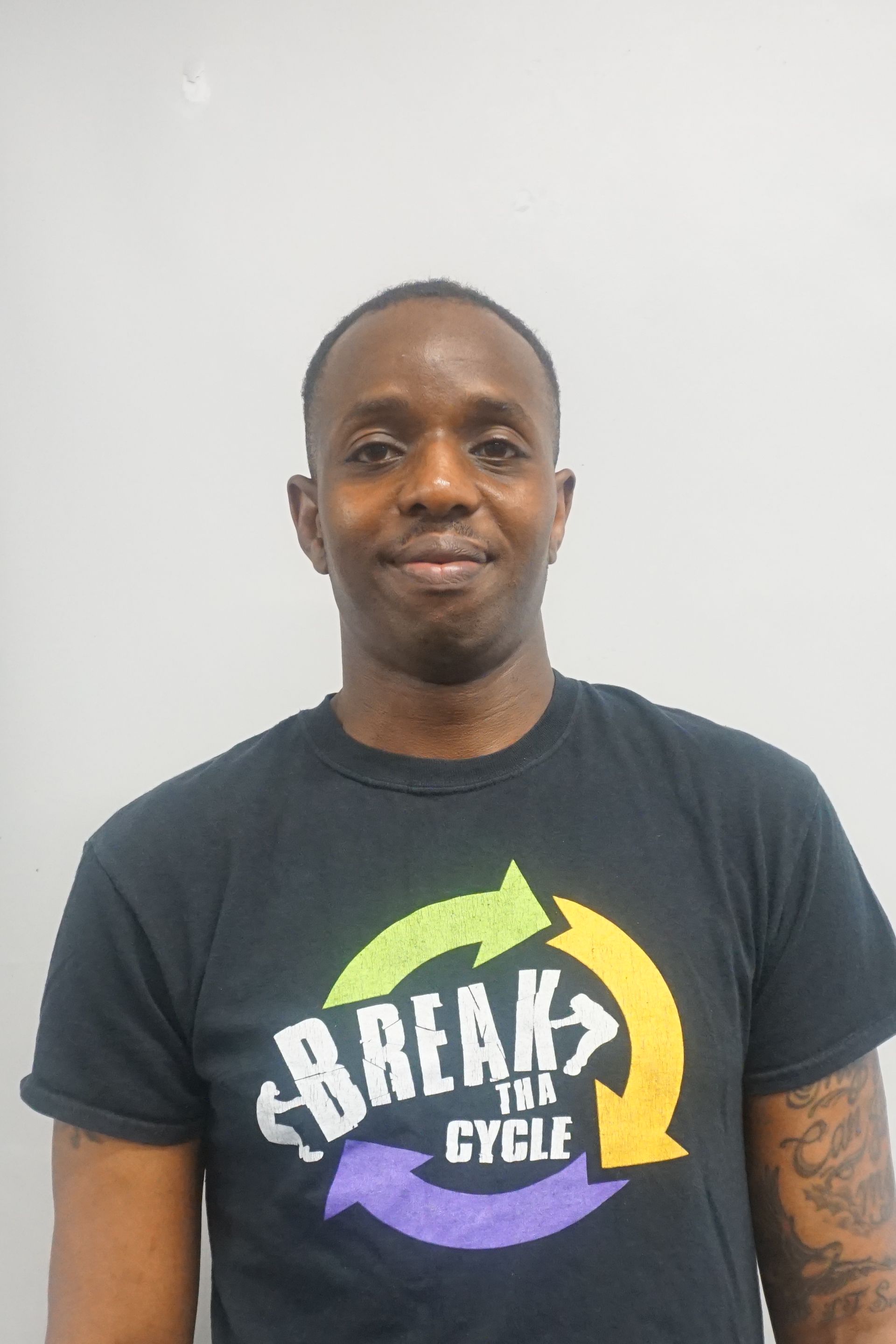A man is wearing a black t-shirt that says break the cycle.