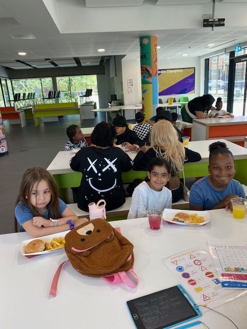 A group of children are sitting at a table in a cafeteria