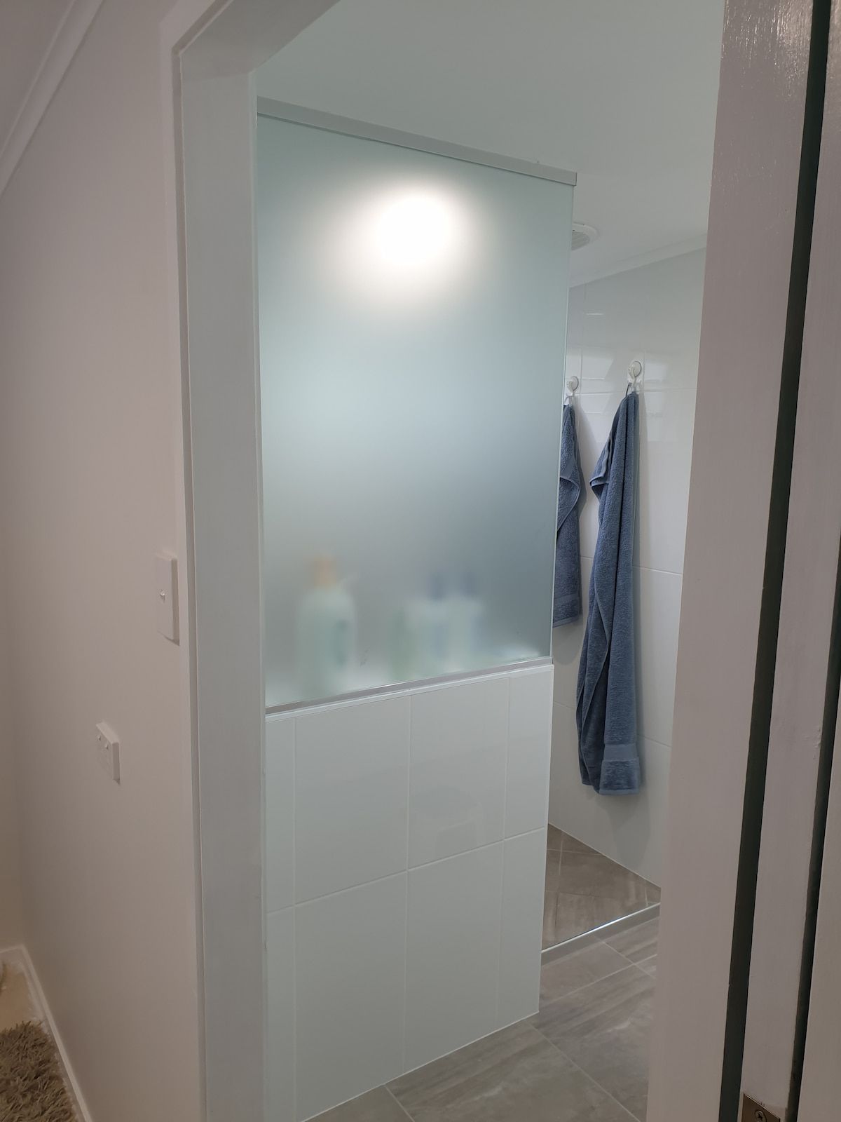 A Hallway with A Frosted Glass Door Leading to A Bathroom — Gaspen Builders & Carpenters in Kirwan, QLD