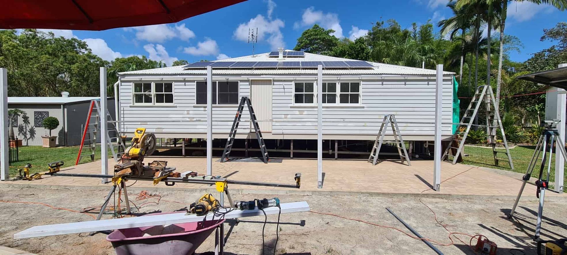 A House is Being Built in a Backyard With a Wheelbarrow in the Foreground — Gaspen Builders & Carpenters in Kirwan, QLD