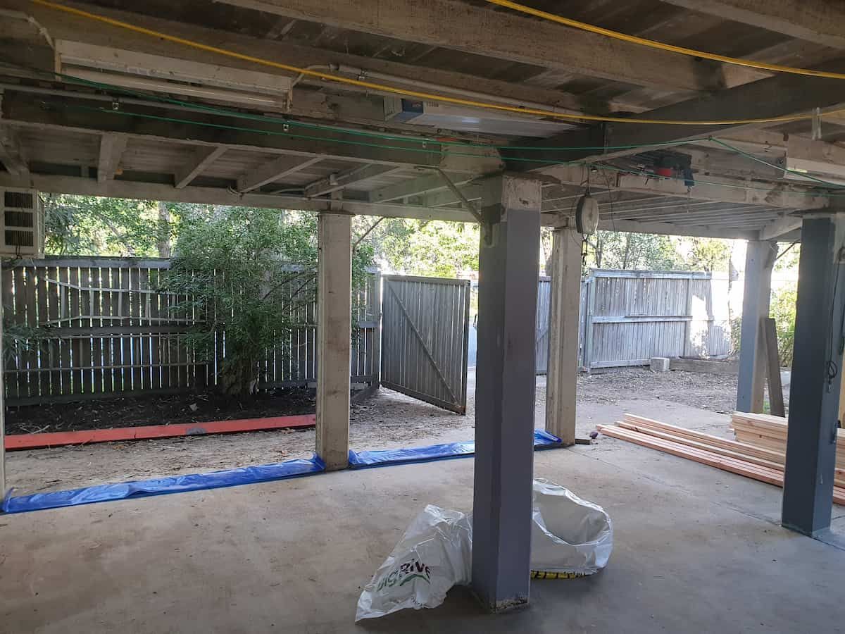 An Empty Basement With Columns and a Fence in the Background — Gaspen Builders & Carpenters in Kirwan, QLD
