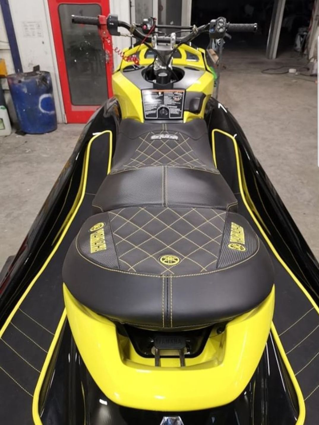 A yellow and black jet ski is parked in a garage