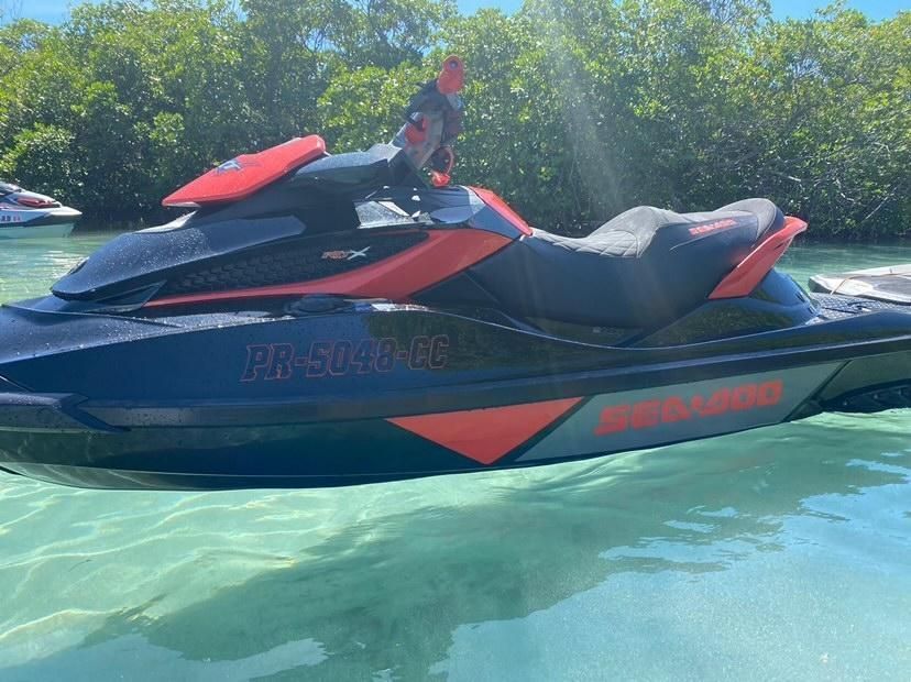 A black and red jet ski is floating on top of a body of water.