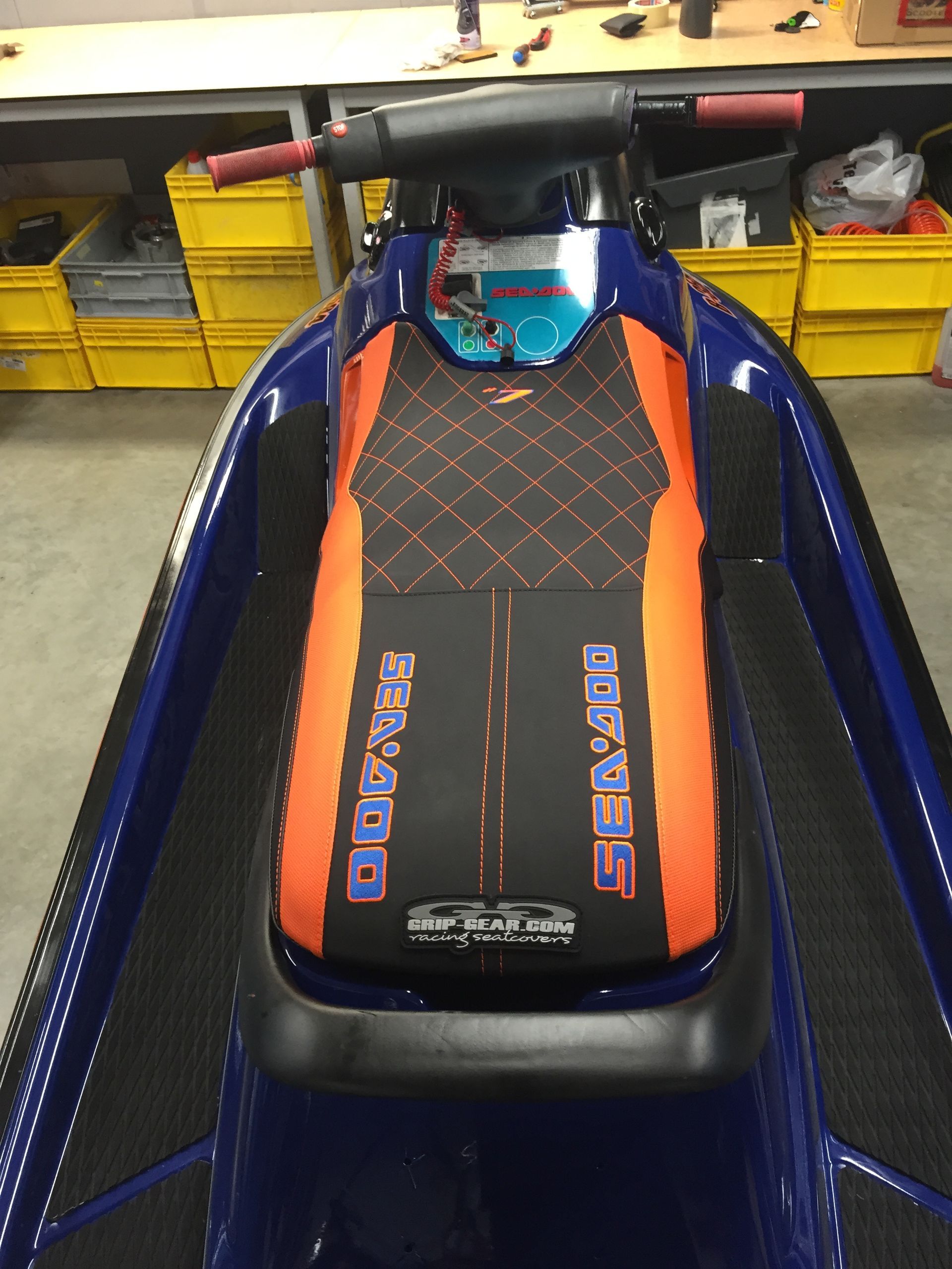 A blue and orange jet ski with the word sea doo on it