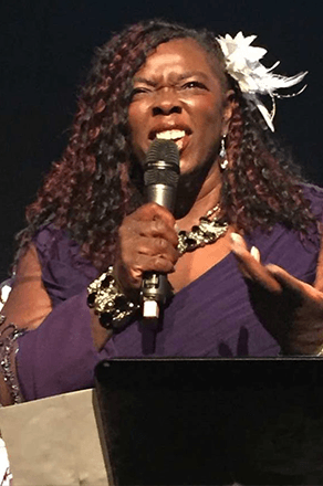 Winnie singing with microphone in hand