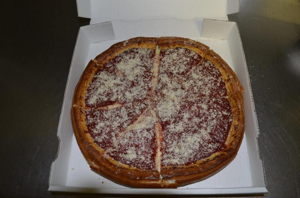Deep dish pizza in a white cardboard box, cut into four slices.