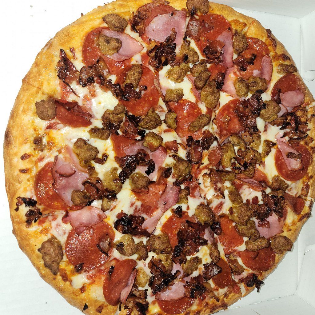 Pizza with pepperoni, sausage, ham, and bacon.