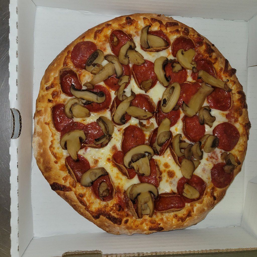Pepperoni and mushroom pizza in a cardboard box.