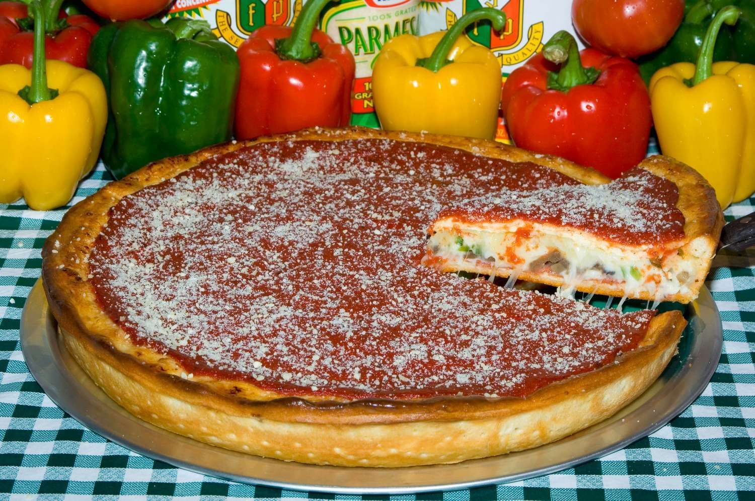 A Chicago style pizza with a slice taken out of it.