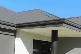 The roof of a house with a porch and a blue sky in the background.