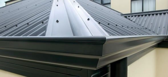 A close up of a gutter on a roof of a house.