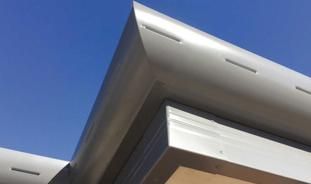 A close up of a roof with a blue sky in the background.