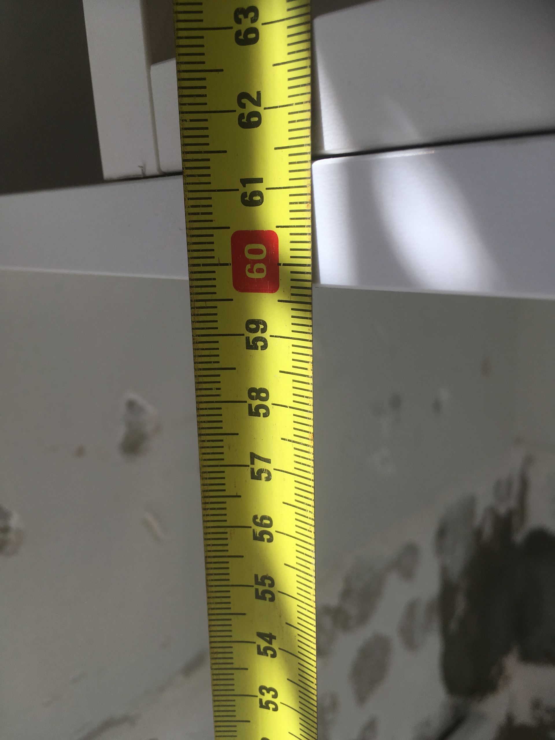 Yellow tape measure indicating 60cm against a white surface.