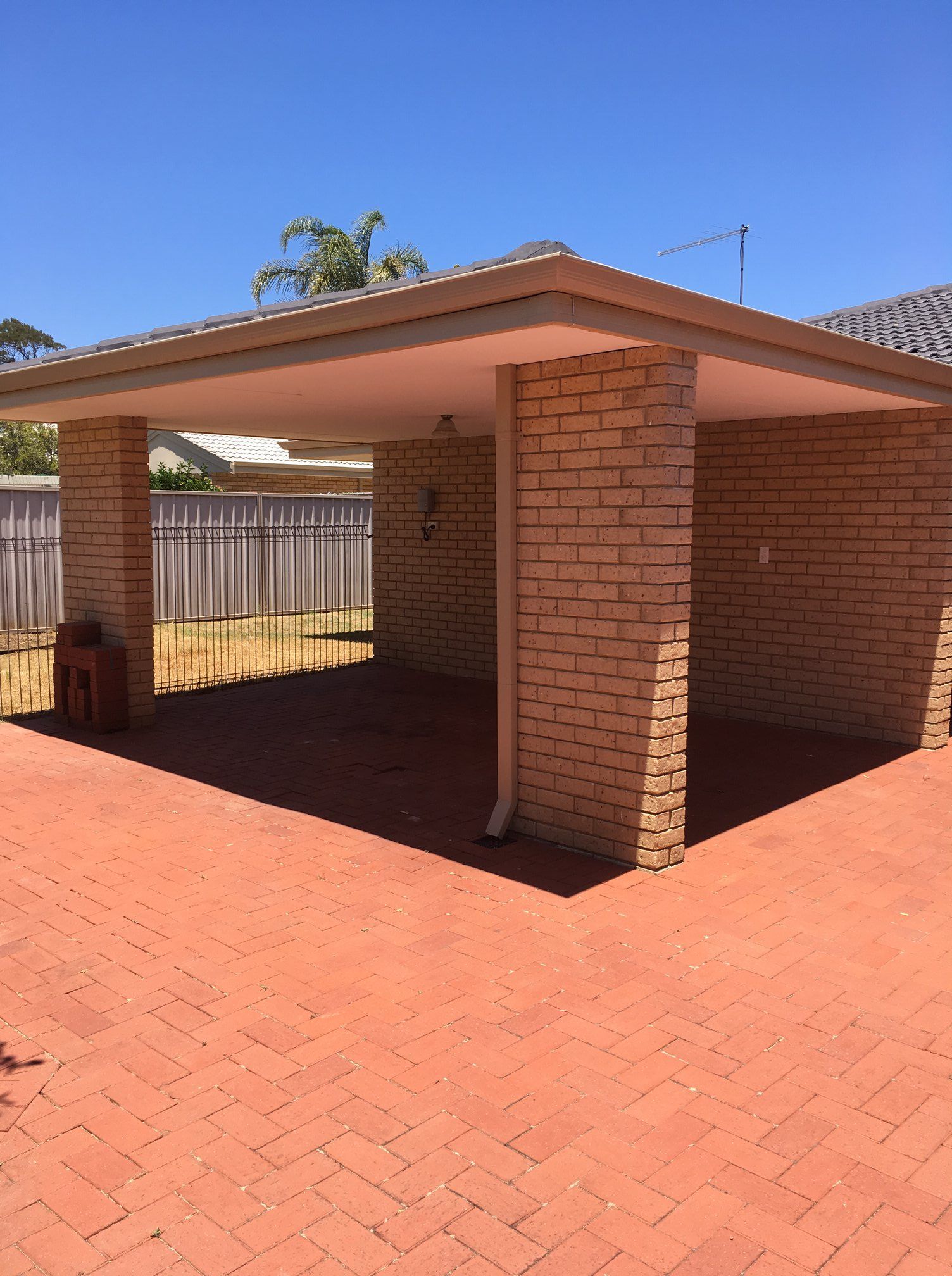 There is a carport in the backyard of a house.