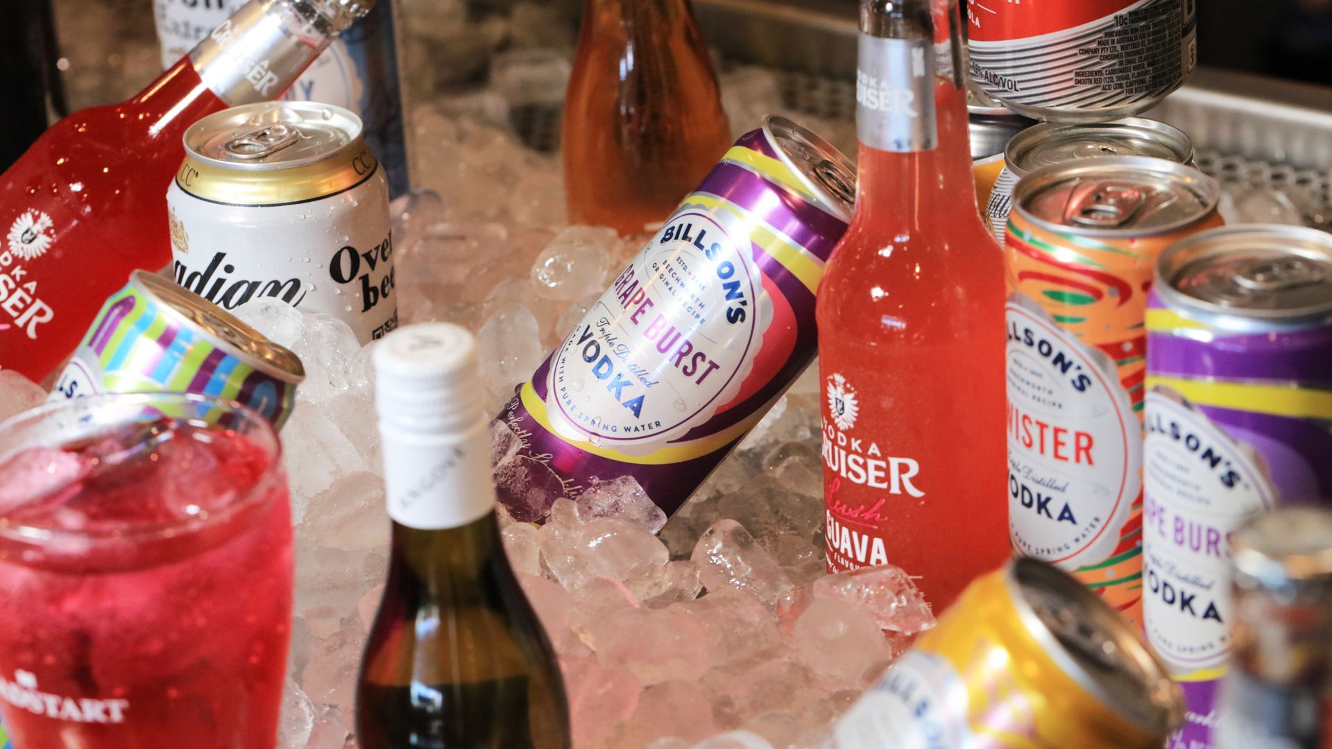 A bunch of cans and bottles of alcohol are sitting on ice.