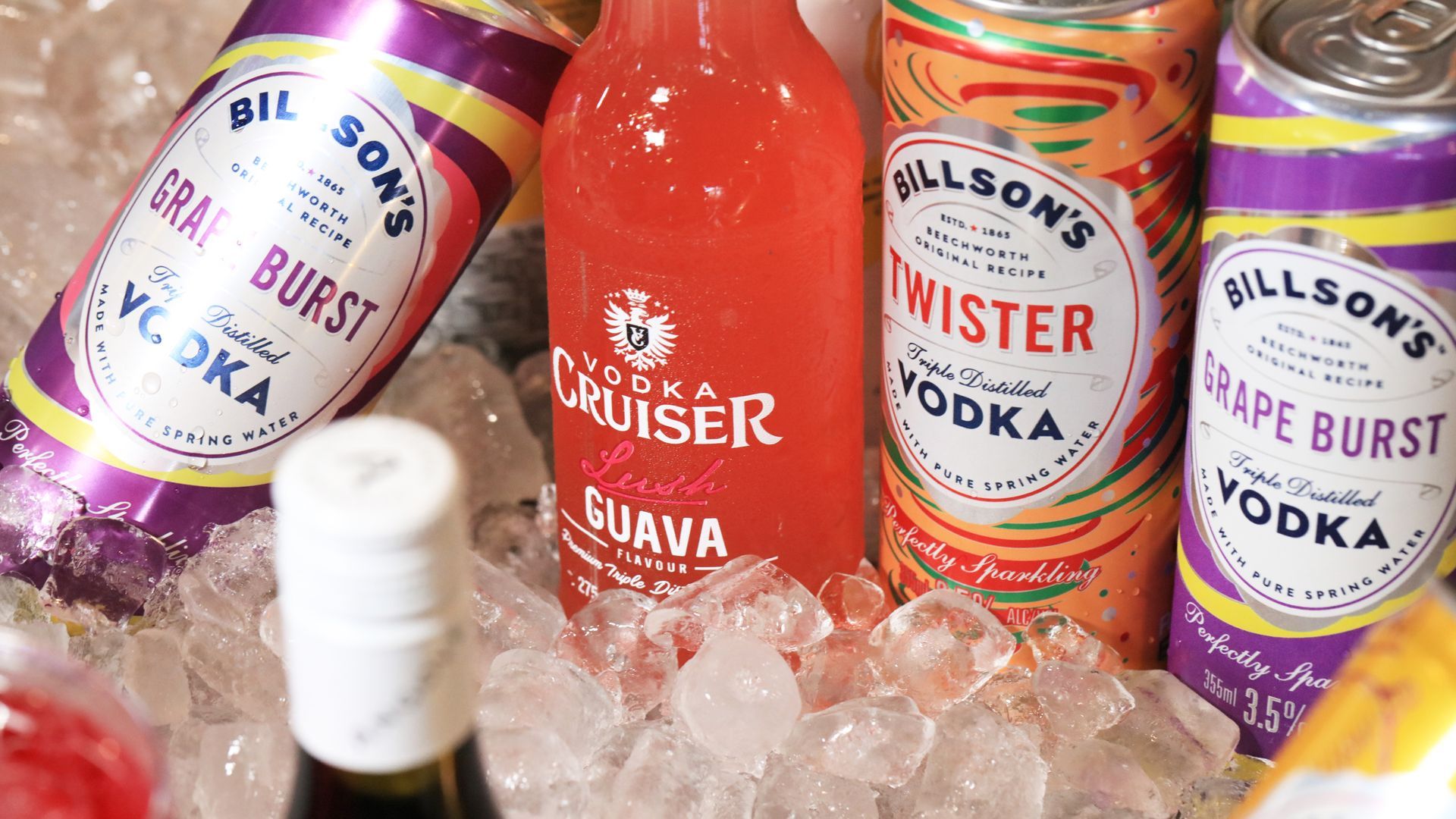 Bottles and cans of vodka are sitting on ice.