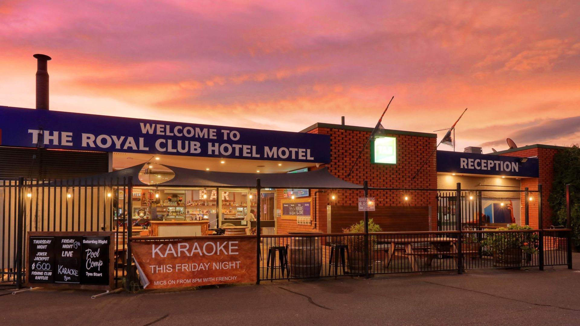 A hotel with a sign that says welcome to the royal club hotel motel