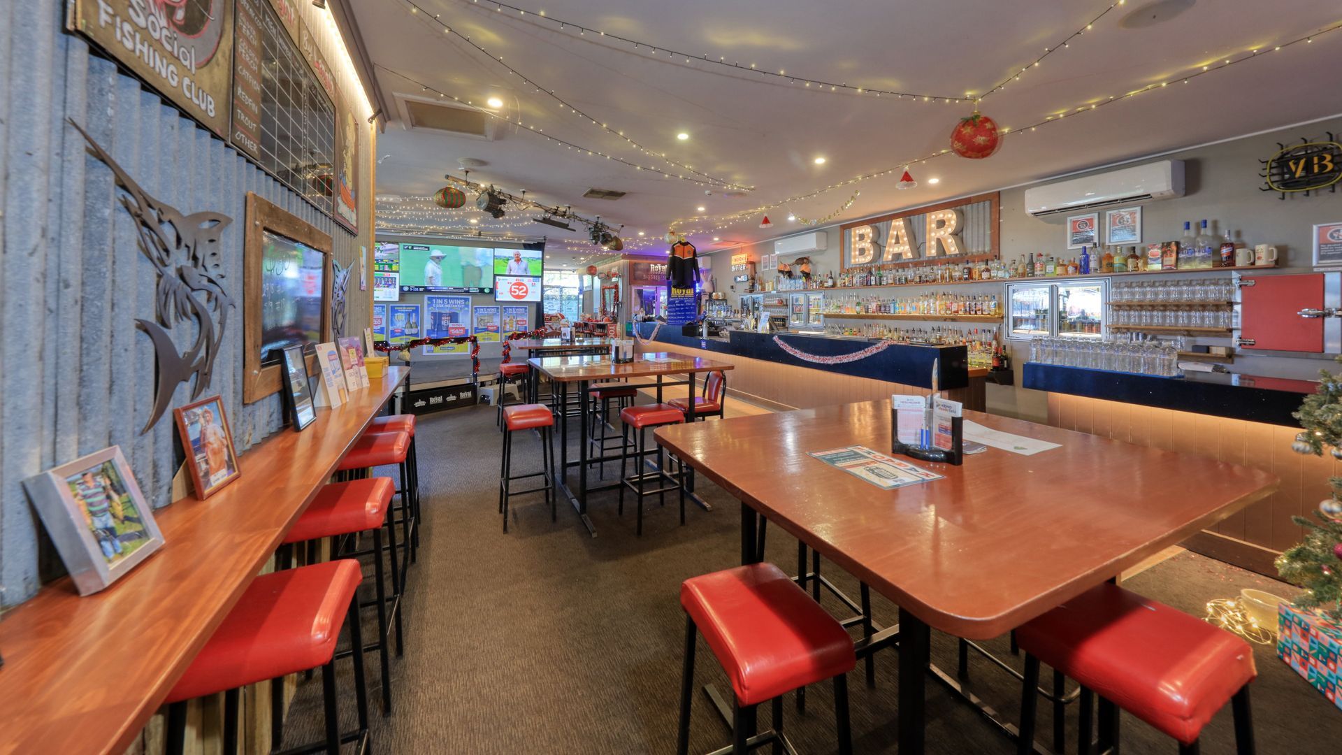 A restaurant with tables and stools and a bar.