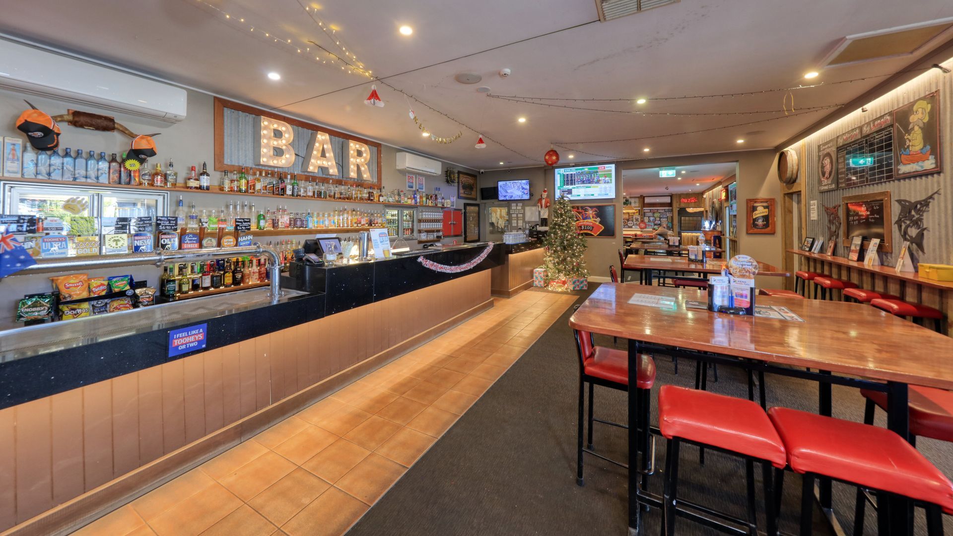 A restaurant with tables and chairs and a bar.