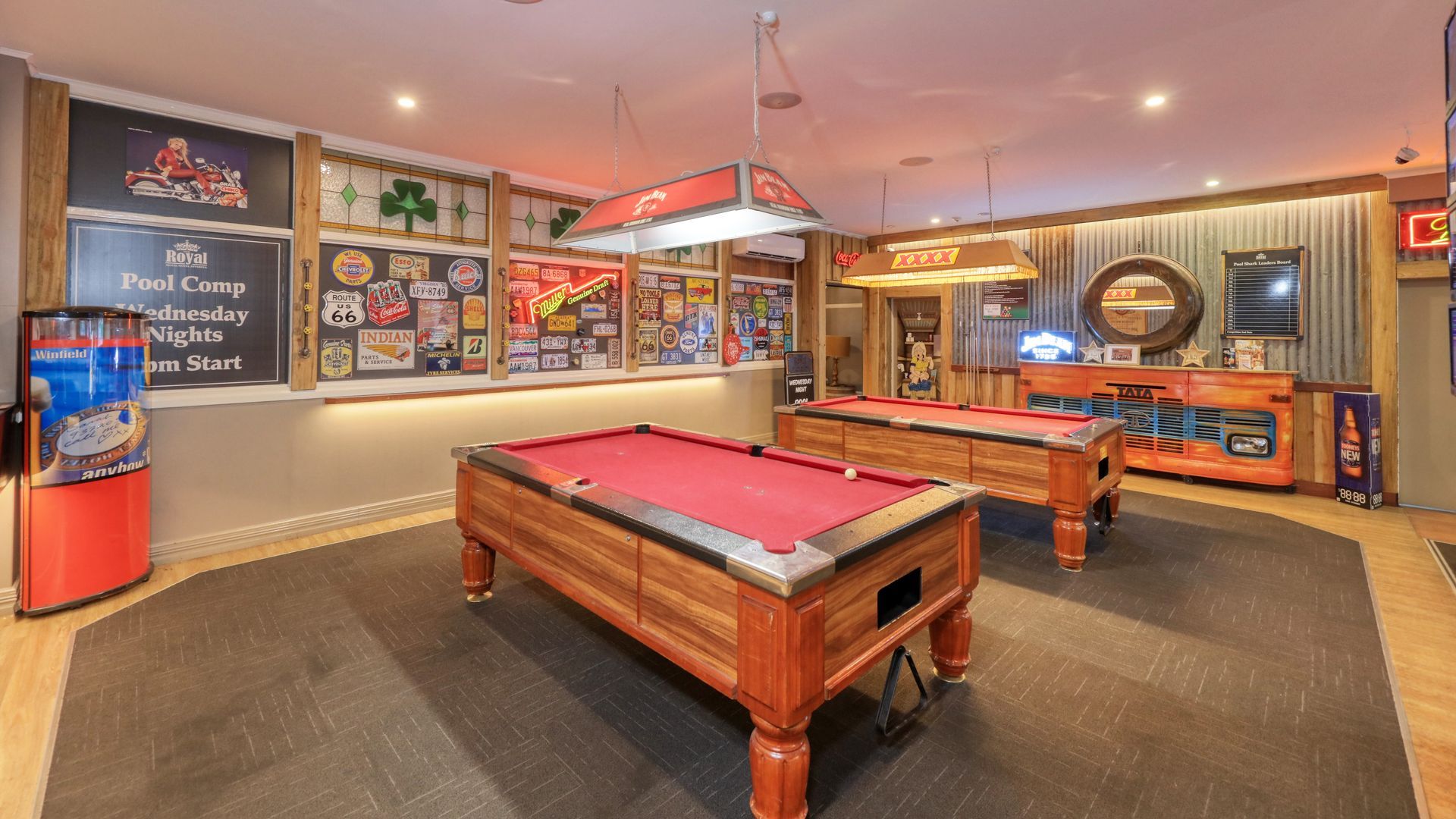 Two pool tables in the room with a quality lights