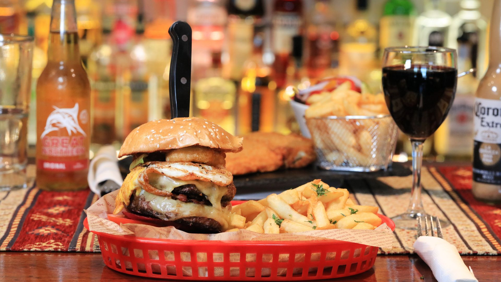 A hamburger and french fries are in a basket on a table.