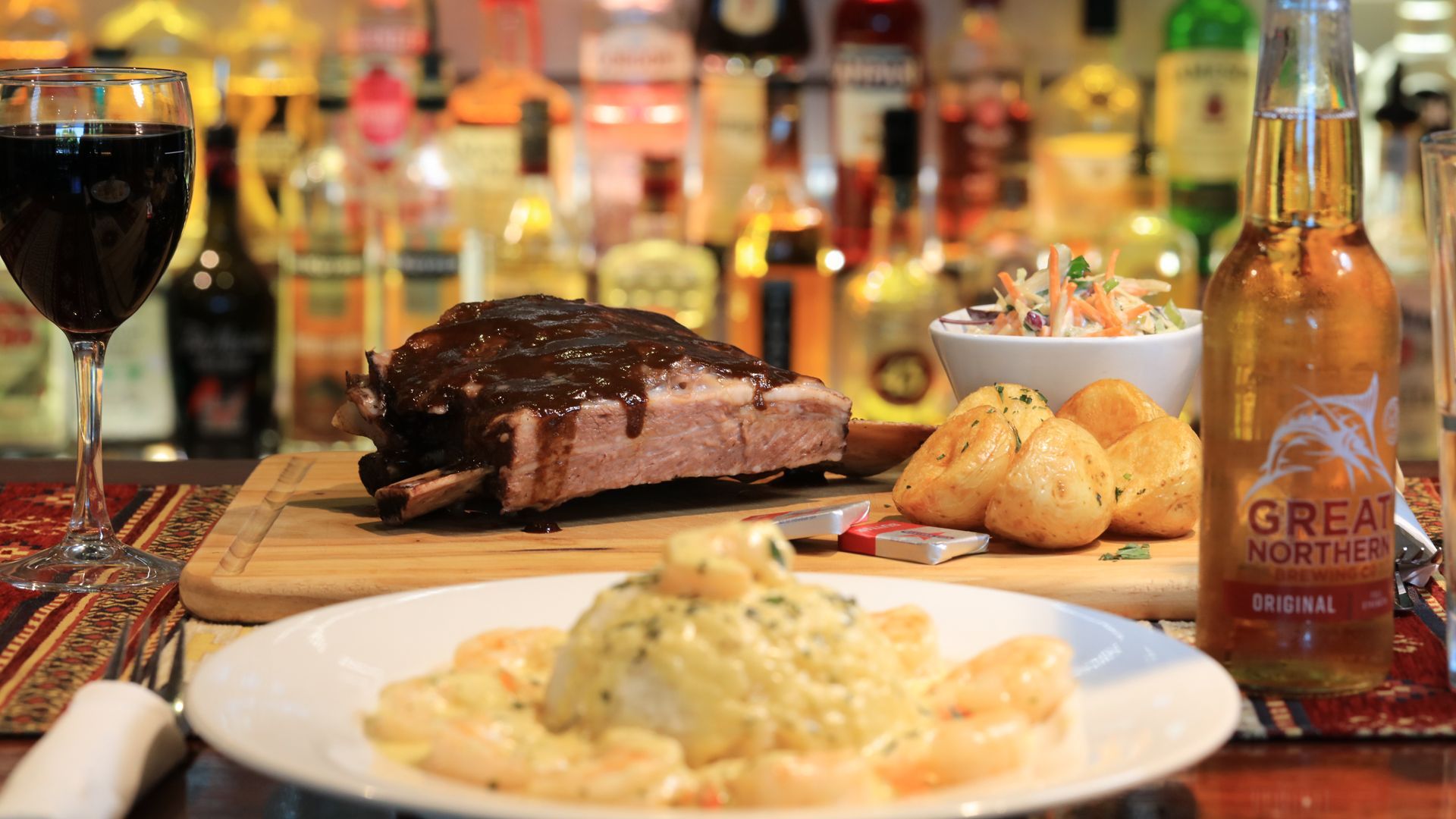 A bottle of great northern beer is next to a plate of food