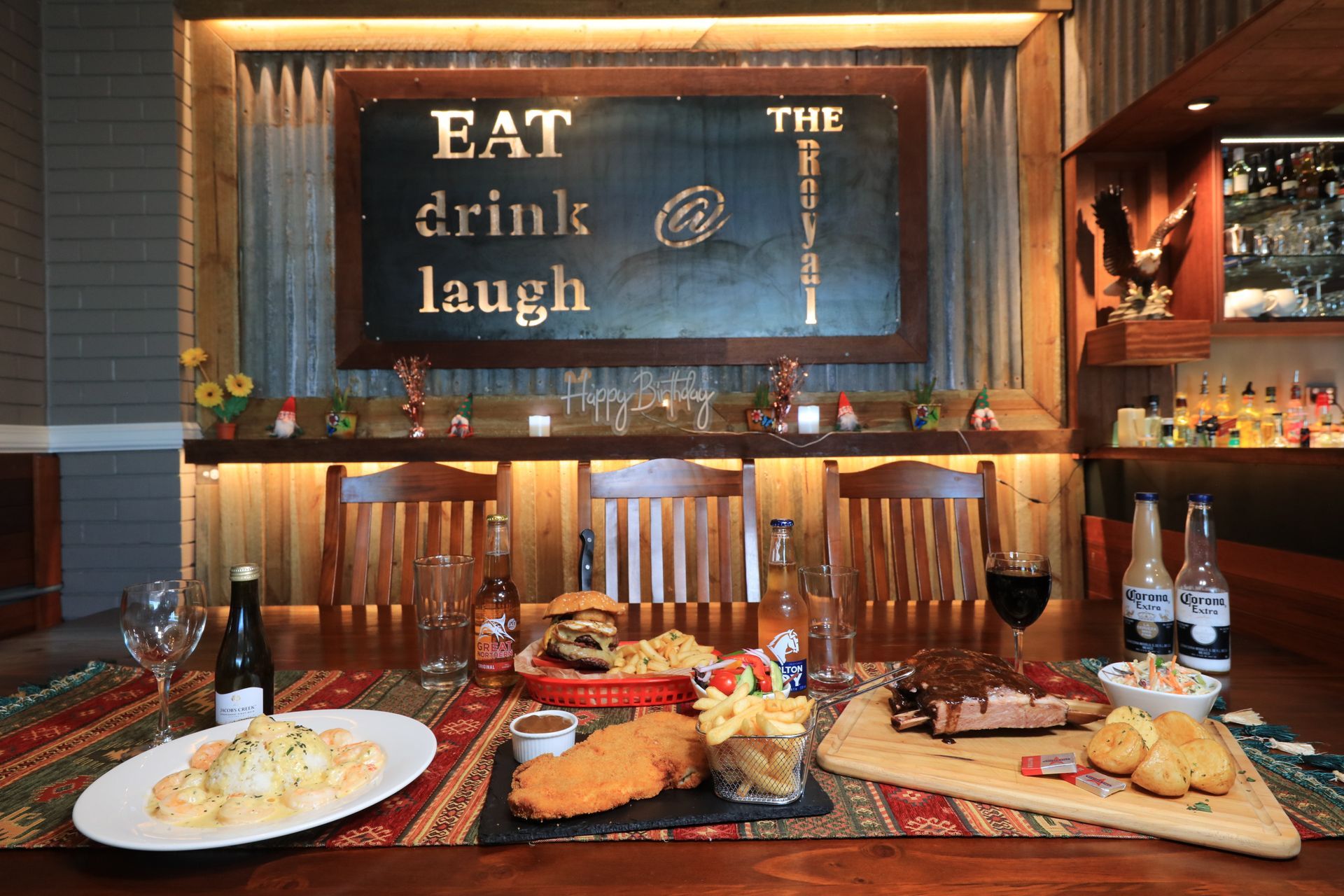 A table with plates of food and a sign that says eat drink laugh