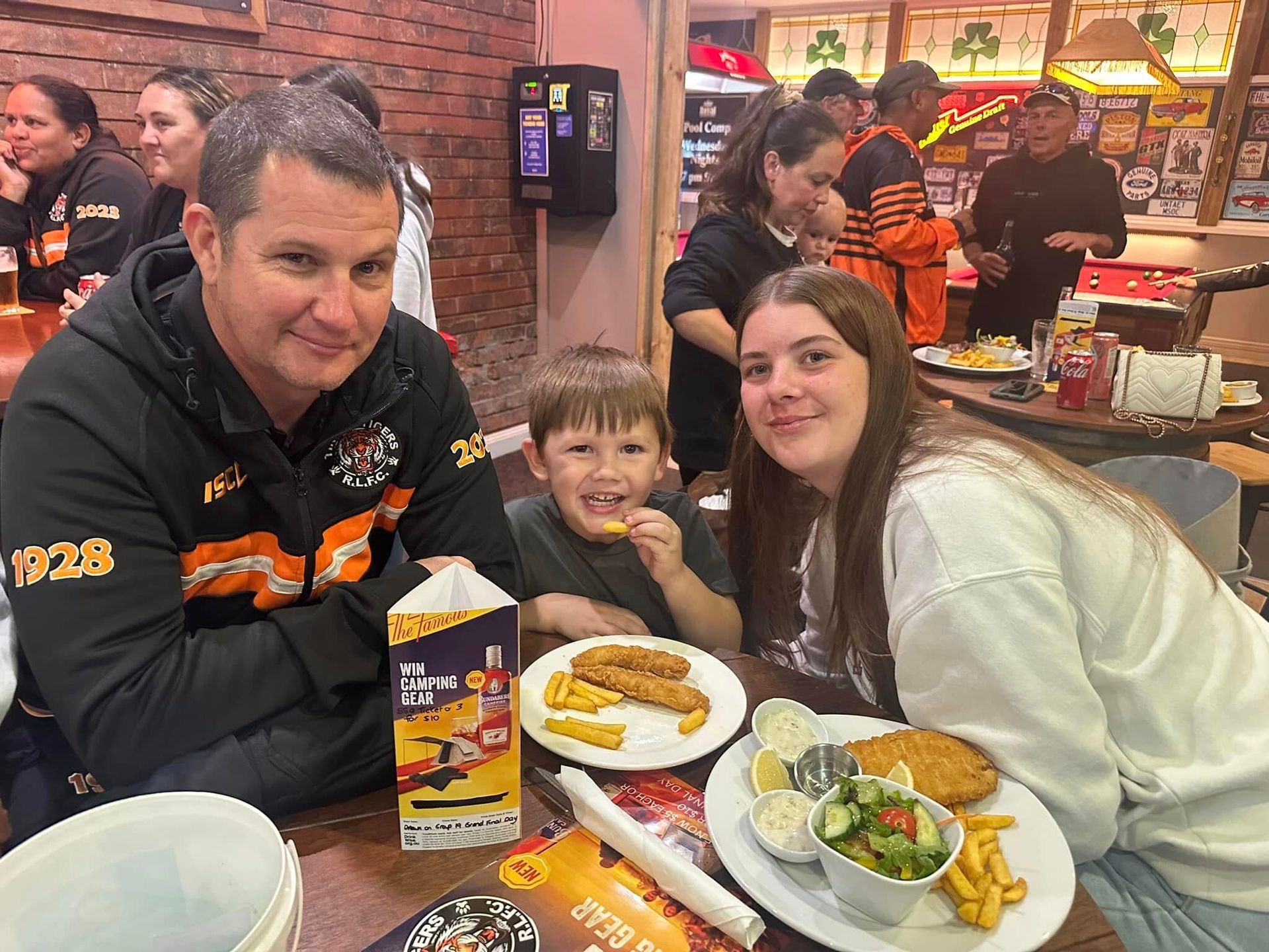 A group of people are sitting at a table with plates of food.