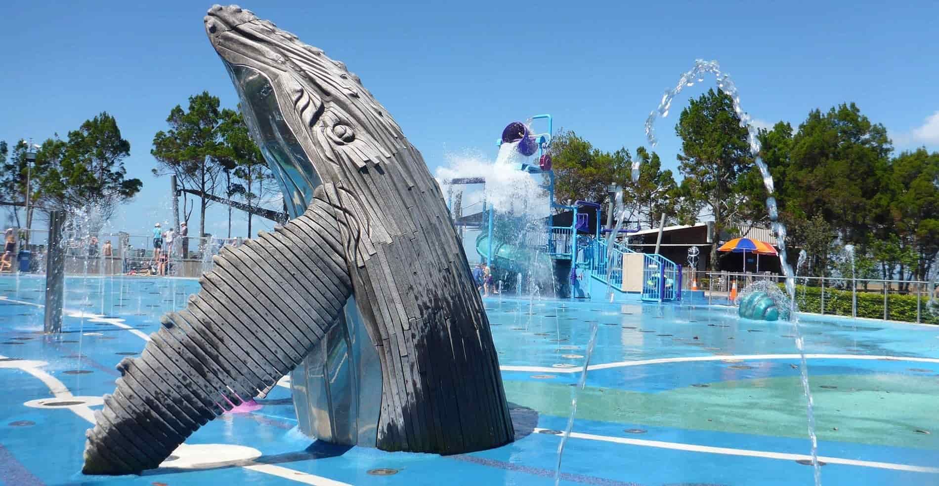 A Statue of a Humpback Whale in a Water Park — Watkins Electrical In Pialba, QLD