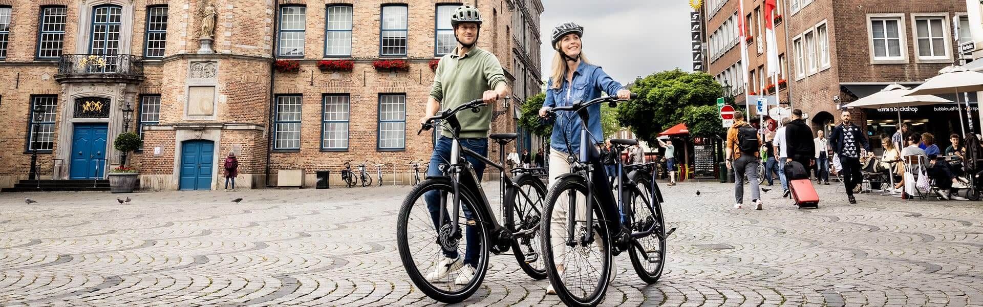 Een man en vrouw op een elektrische fiets. Klik op de afbeelding voor alle elektrische fietsen.