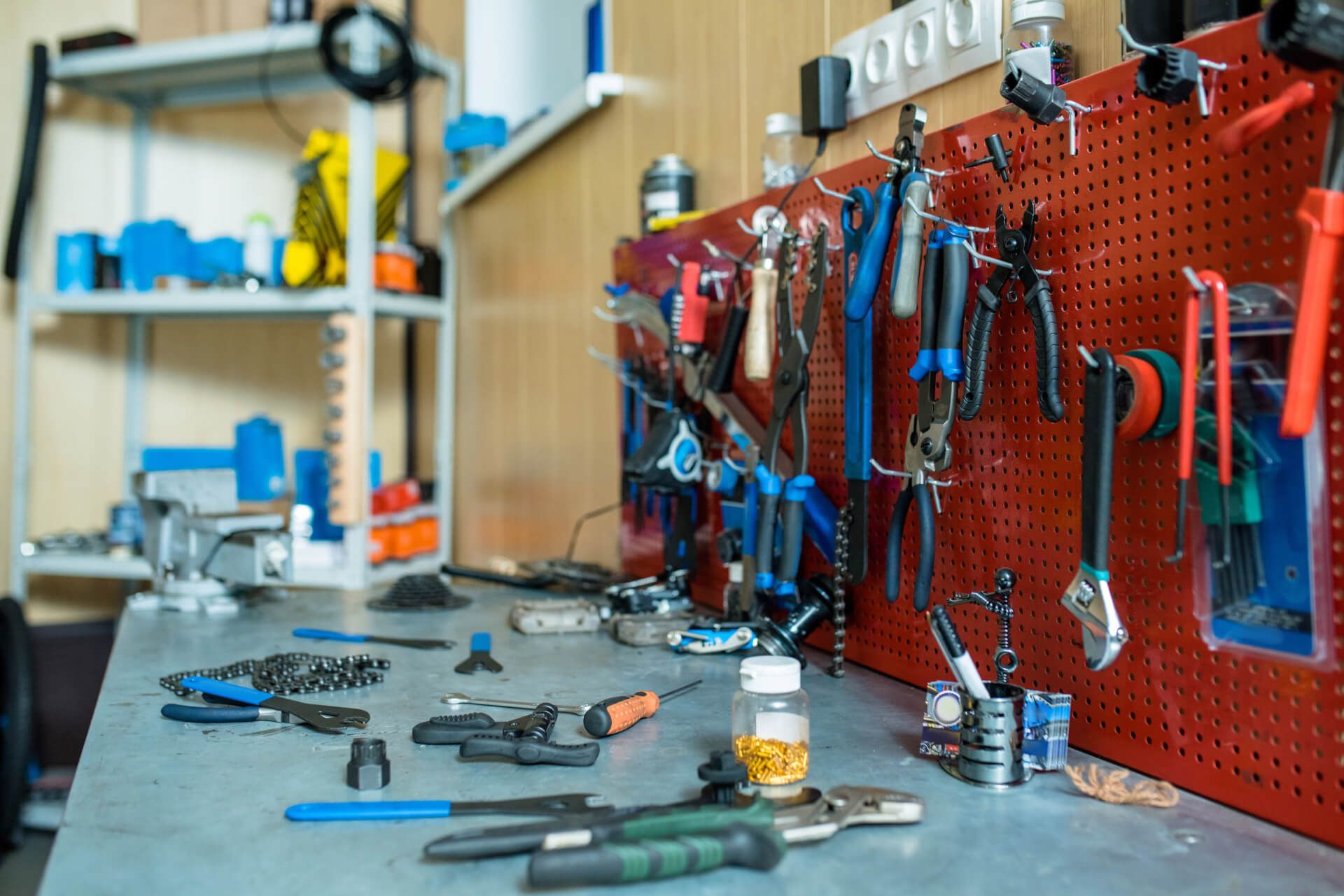 Een werkbank gevuld met veel gereedschap en een flesje olie.