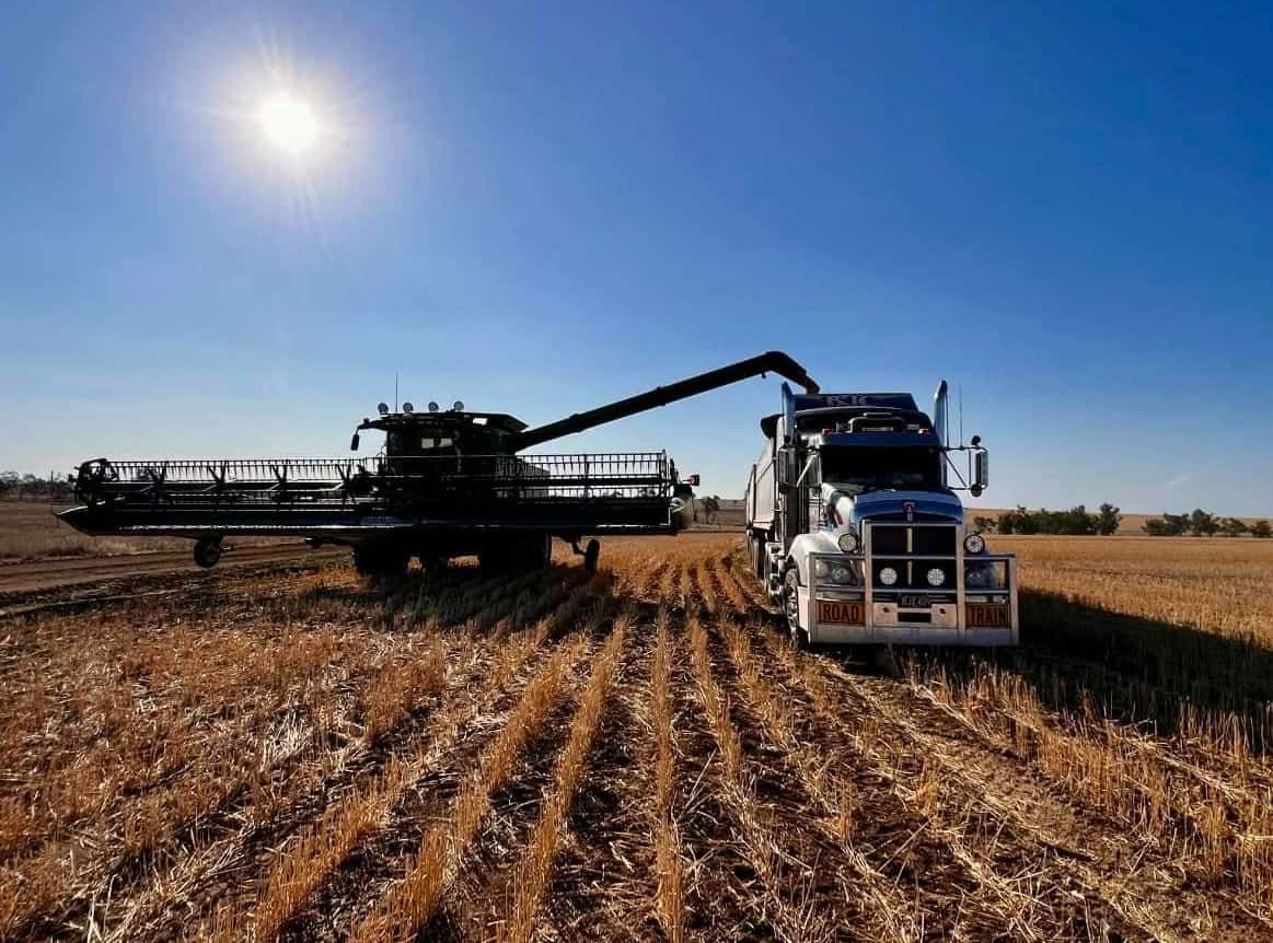 A Combine Harvester Is Being Loaded Onto A Semi Truck In A Field — BJC Transport In Wondai, QLD