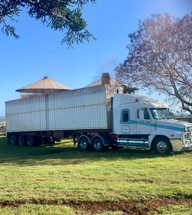 A White Semi Truck Is Parked In A Grassy Field — BJC Transport In Wondai, QLD