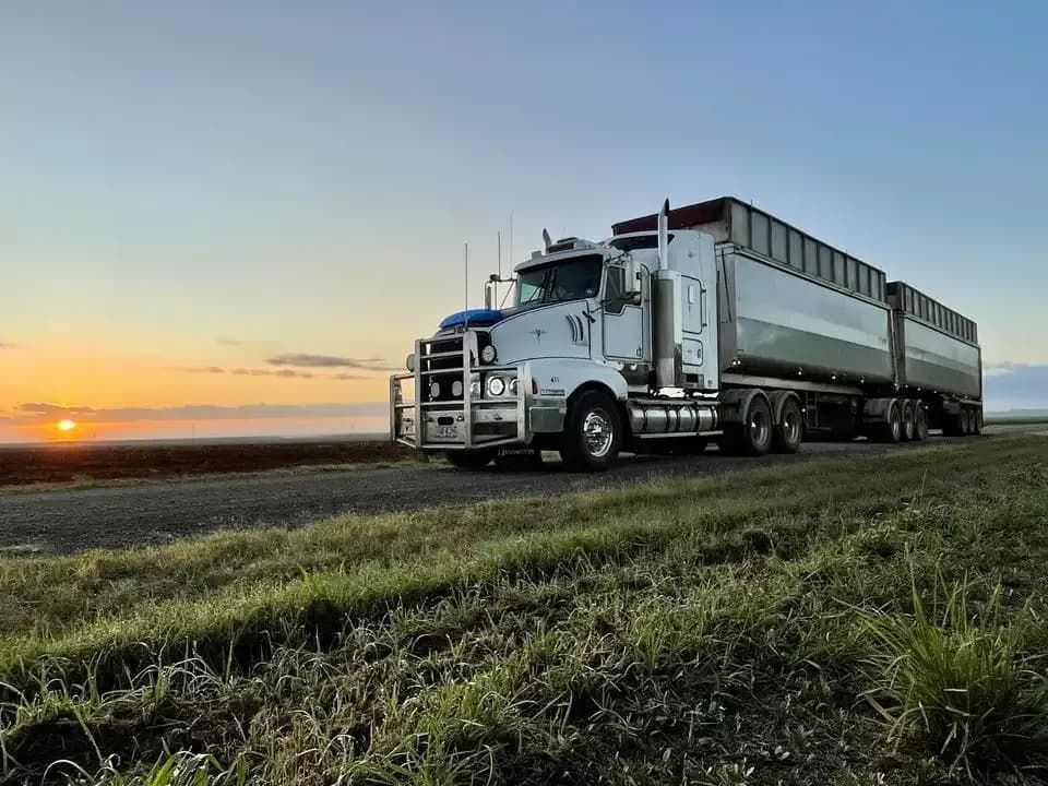 A Semi Truck Is Parked On The Side Of The Road In A Field At Sunset — BJC Transport In Wondai, QLD