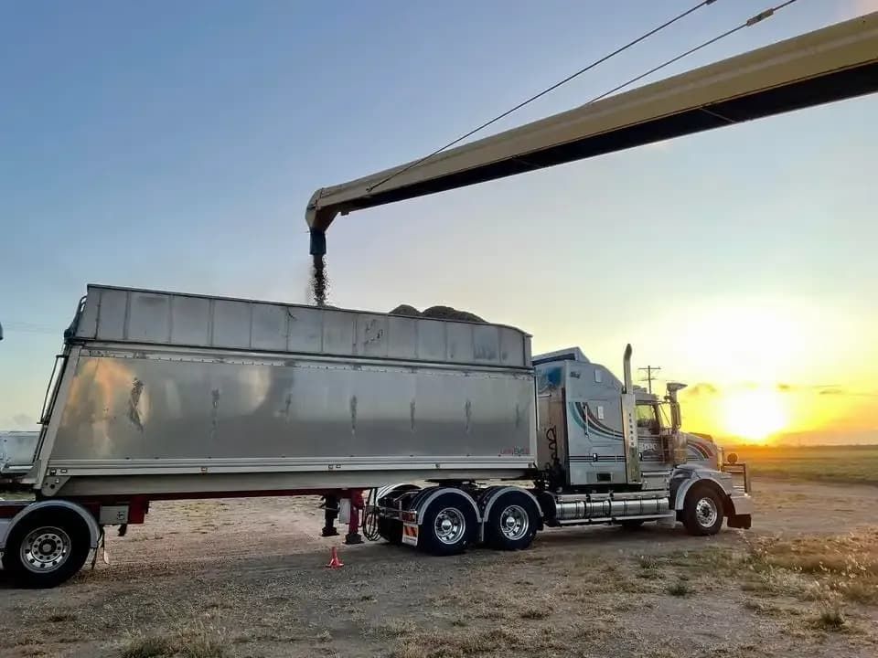 A Semi Truck Is Being Loaded With Grain By A Crane — BJC Transport In Wondai, QLD