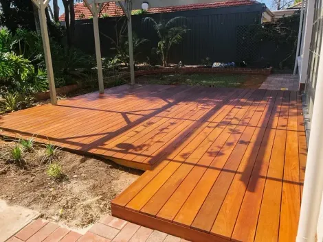 Wooden deck patio with orange planks and shadows in a garden yard Wooden deck patio with orange planks and shadows in a garden yard