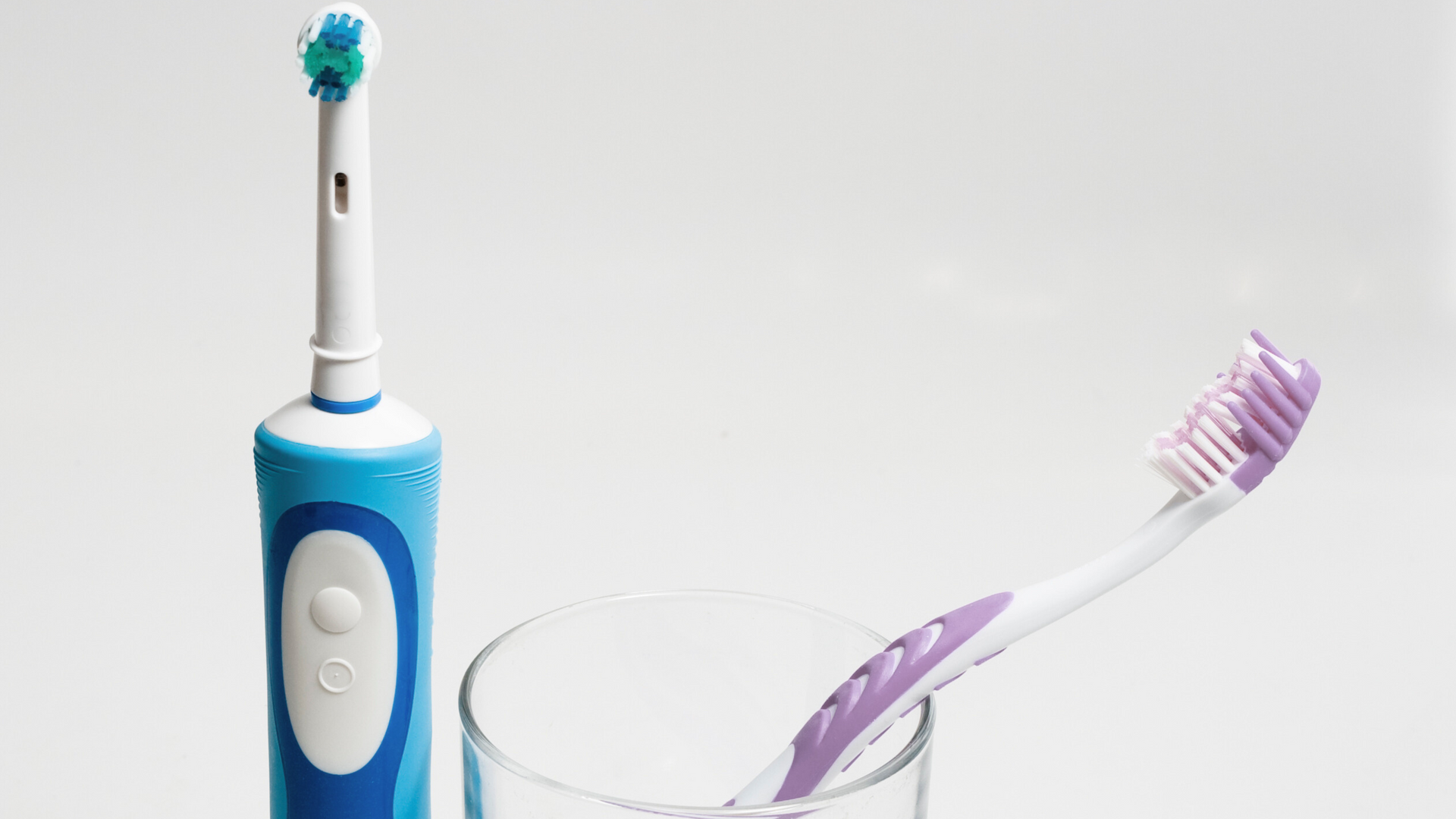 Blue electric toothbrushes and purple manual toothbrush