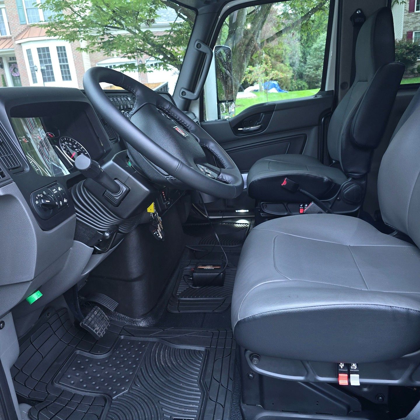 The inside of a truck with a steering wheel and seats