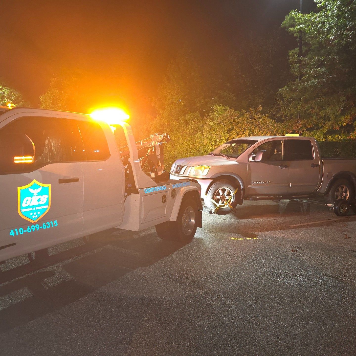 A tow truck is towing a truck that has a flat tire.